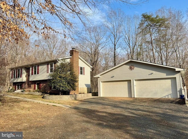 view of side of home with a garage, a chimney, and an outdoor structure