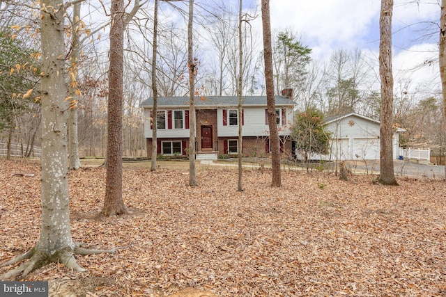 raised ranch with brick siding, a garage, and a chimney