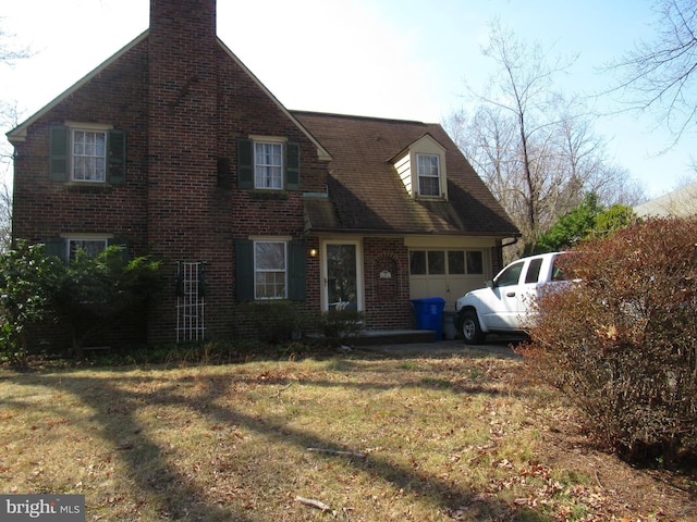 view of front of property with a front lawn, brick siding, and a chimney