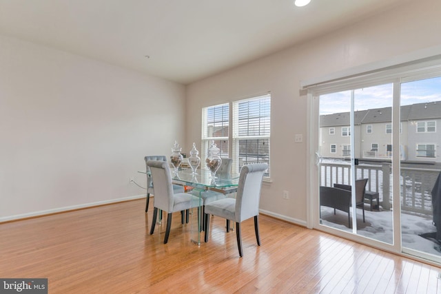 dining space with baseboards and wood finished floors