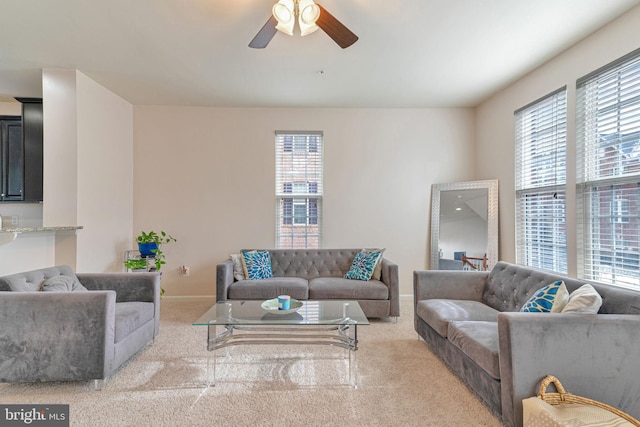 living room with baseboards, carpet floors, and a ceiling fan