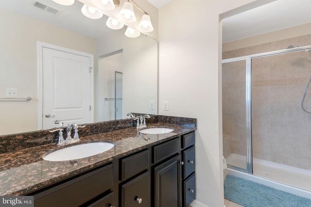 bathroom featuring a sink, visible vents, a stall shower, and double vanity