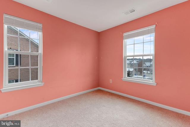 carpeted empty room featuring visible vents and baseboards