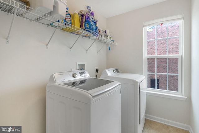 laundry area with laundry area, washer and dryer, and baseboards