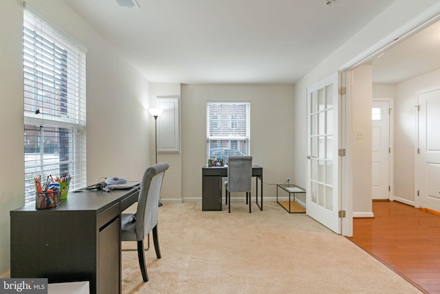 office space with baseboards and light carpet