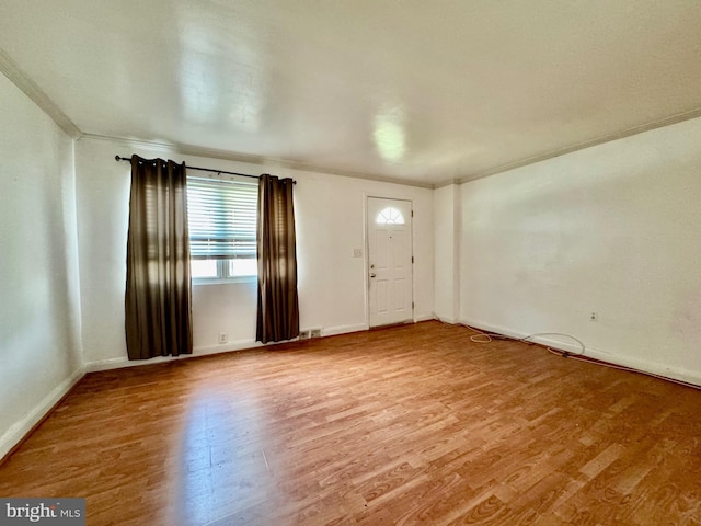 interior space featuring light wood-type flooring, baseboards, and ornamental molding