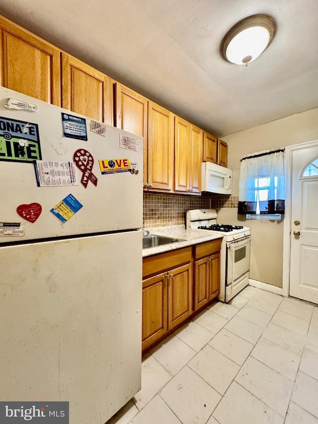 kitchen featuring a sink, white appliances, light tile patterned flooring, decorative backsplash, and light countertops