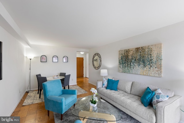 living area with baseboards and wood finished floors