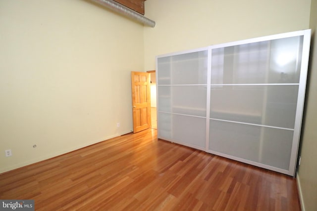 unfurnished bedroom with a high ceiling and wood finished floors