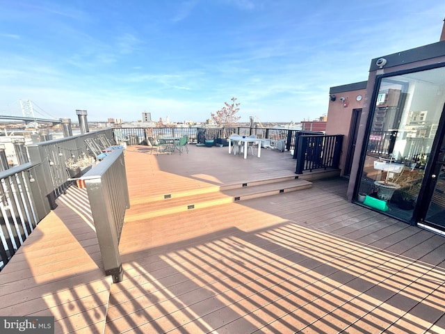 wooden deck featuring a view of city and outdoor dining area