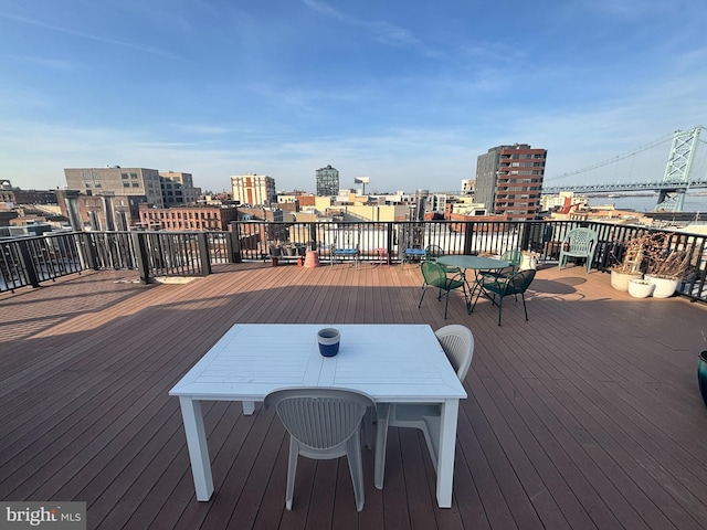 wooden deck with a view of city and outdoor dining space