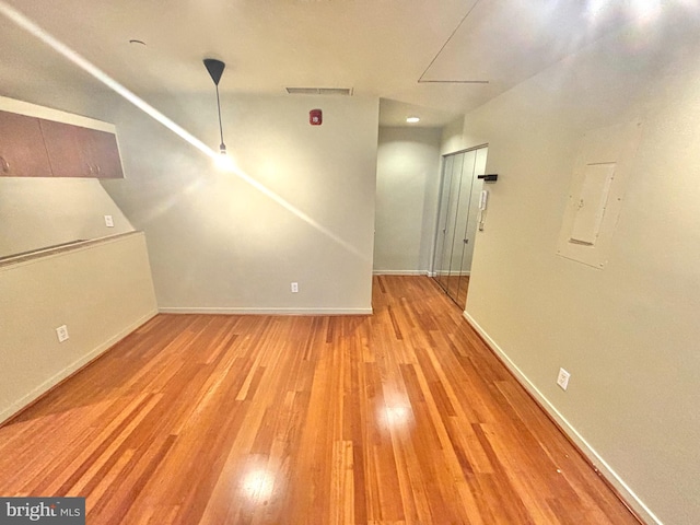 interior space with light wood finished floors, visible vents, and baseboards