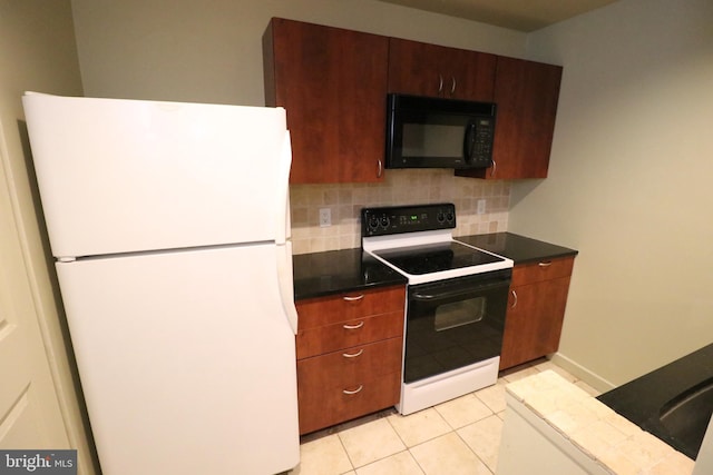 kitchen with dark countertops, backsplash, black microwave, freestanding refrigerator, and electric range