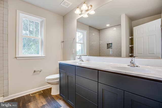 bathroom featuring a sink, visible vents, plenty of natural light, and wood finished floors