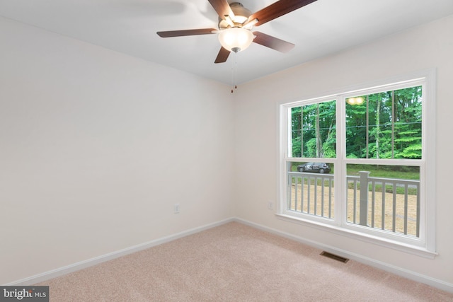 empty room featuring a ceiling fan, carpet, visible vents, and baseboards