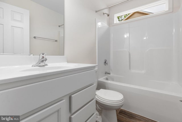 bathroom featuring toilet, vanity,  shower combination, and wood finished floors