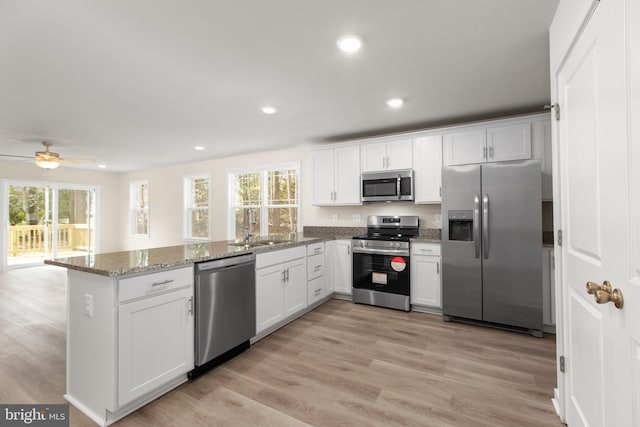 kitchen featuring a sink, a peninsula, plenty of natural light, and stainless steel appliances