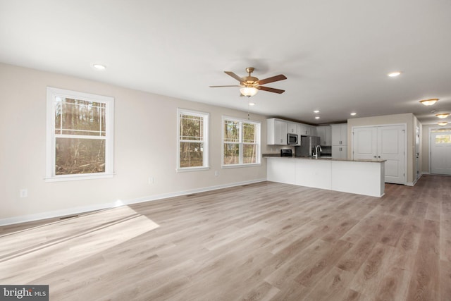 unfurnished living room with recessed lighting, baseboards, light wood-style flooring, and a ceiling fan