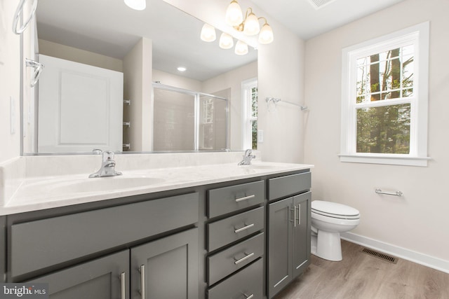 full bathroom with visible vents, double vanity, a sink, a shower stall, and toilet