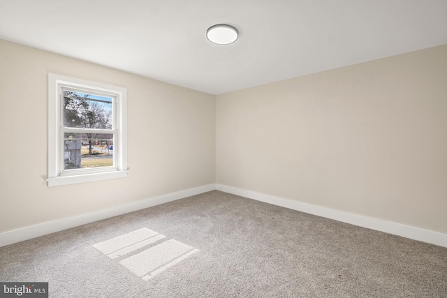 spare room with baseboards and carpet