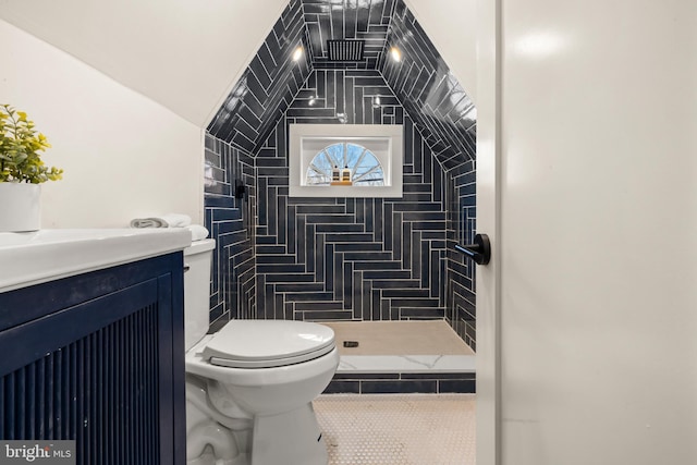 bathroom featuring a tile shower, tile patterned flooring, toilet, and vanity