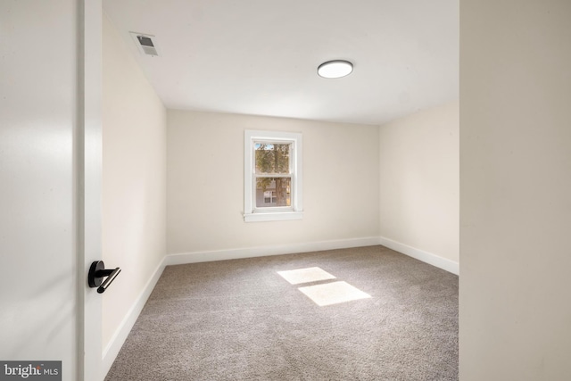 carpeted spare room with baseboards and visible vents