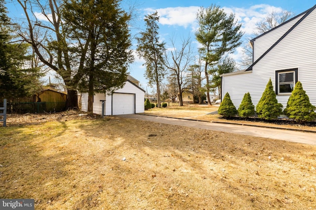 view of yard featuring an outbuilding, a garage, and fence