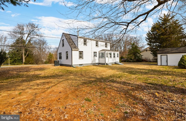 view of front of home with central air condition unit, an outdoor structure, a front yard, and a shingled roof