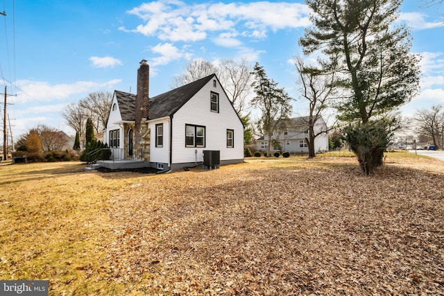 view of property exterior with cooling unit and a chimney