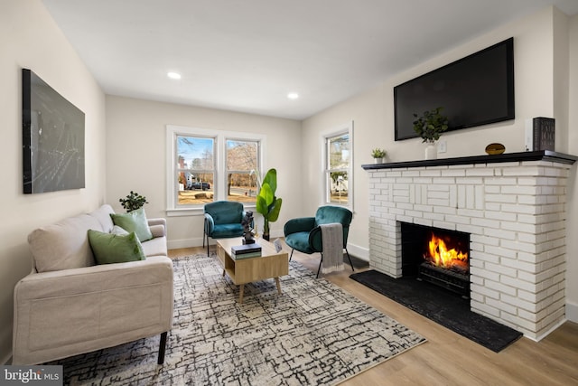 living area with recessed lighting, baseboards, wood finished floors, and a fireplace