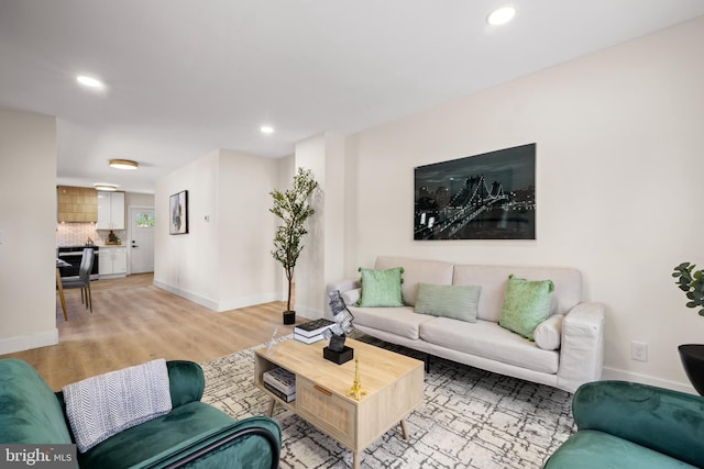 living area featuring recessed lighting, baseboards, and light wood-type flooring