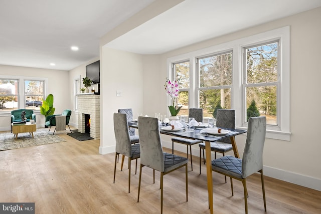 dining area with recessed lighting, baseboards, wood finished floors, and a fireplace