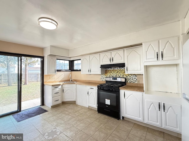 kitchen with black gas range oven, white cabinets, and under cabinet range hood