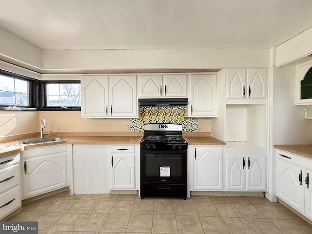 kitchen with black gas range, under cabinet range hood, a sink, backsplash, and white cabinets