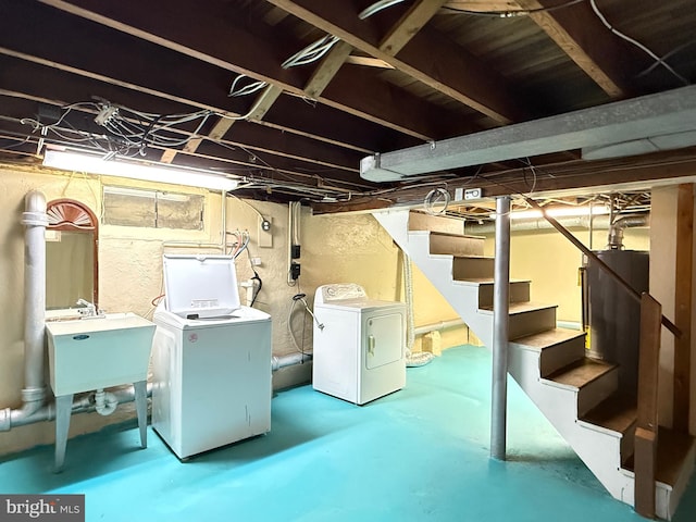 basement with washing machine and dryer, stairs, and a sink