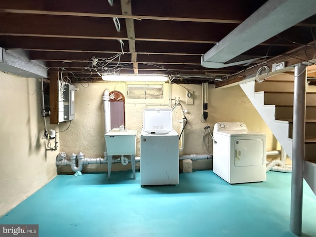 unfinished basement featuring washer and dryer, stairway, a textured wall, and a sink