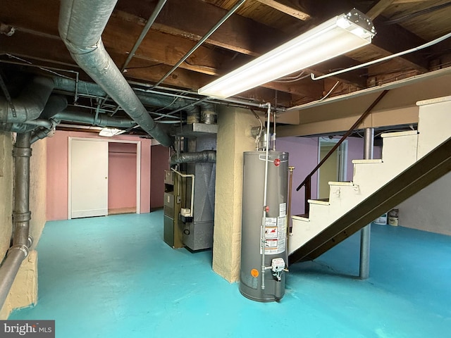 below grade area featuring heating unit, stairway, and gas water heater