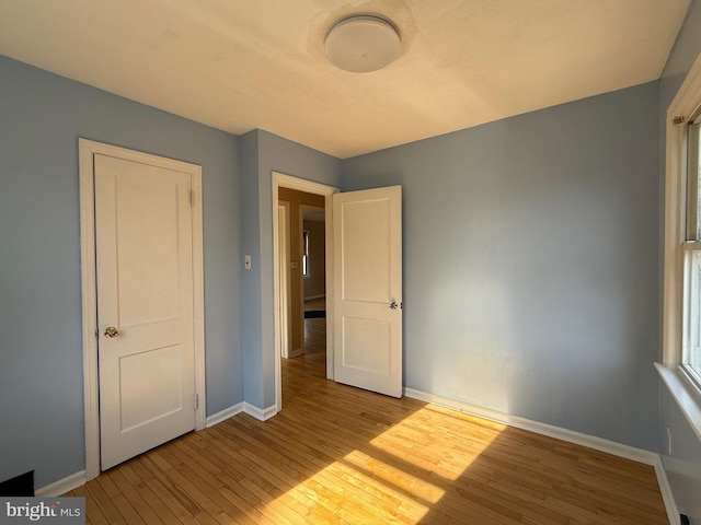 unfurnished bedroom with baseboards and hardwood / wood-style floors