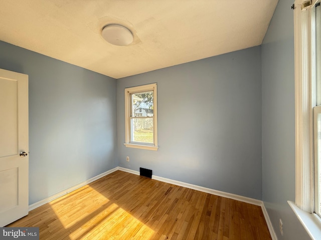 empty room featuring baseboards and wood-type flooring