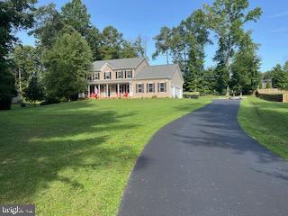 view of front of house with driveway, an attached garage, and a front lawn
