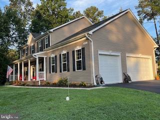 view of front facade with aphalt driveway, a front yard, and an attached garage