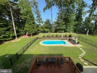 view of pool with a wooden deck, a lawn, a fenced in pool, and a fenced backyard