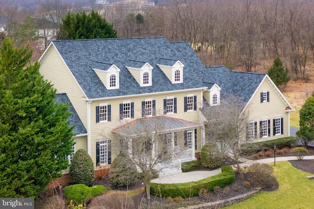 view of front facade featuring roof with shingles and a porch