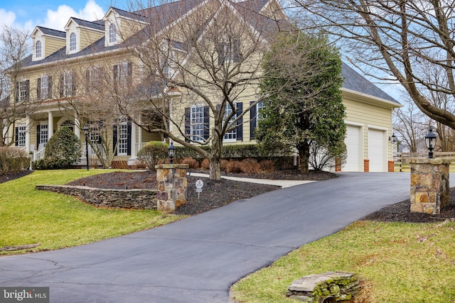 view of front facade with a front lawn, a garage, and driveway