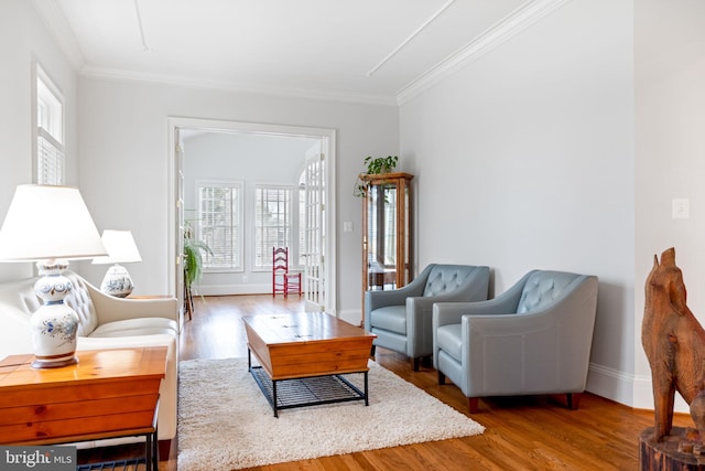 living room featuring ornamental molding, baseboards, and wood finished floors