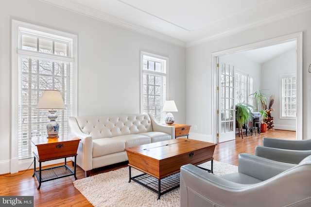 living room featuring a wealth of natural light, baseboards, light wood-style floors, and ornamental molding