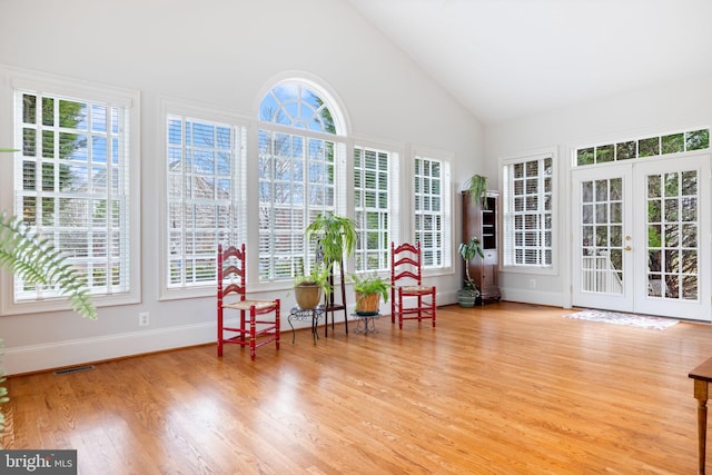 sunroom / solarium with plenty of natural light, visible vents, french doors, and lofted ceiling