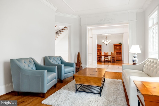 living room featuring crown molding, an inviting chandelier, and wood finished floors