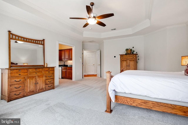 bedroom featuring visible vents, light carpet, ornamental molding, a tray ceiling, and connected bathroom