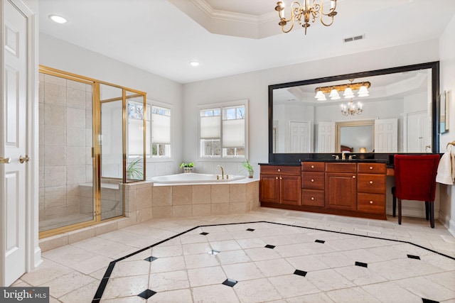 bathroom with an inviting chandelier, a tray ceiling, and ornamental molding